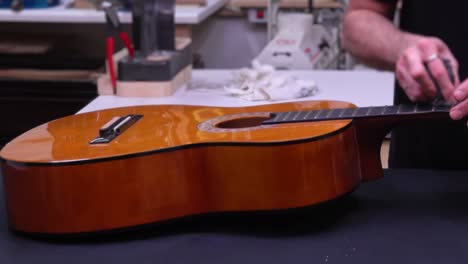 man assembling acoustic guitar. fast motion