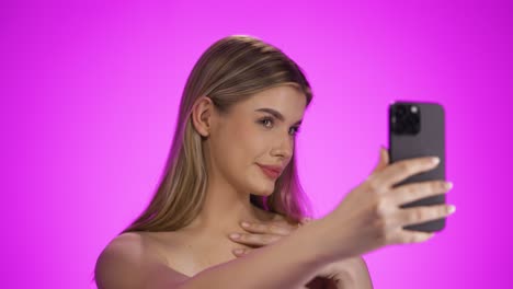 toma media de una joven influyente bonita o modelo en transmisión en vivo en las redes sociales sacando su lengua a sus seguidores frente a un fondo púrpura en cámara lenta
