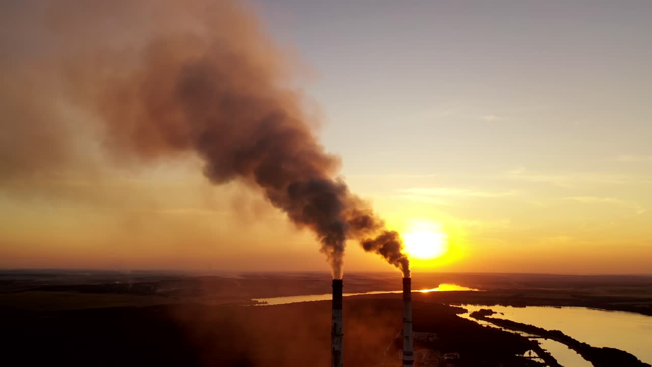 Air pollution over power plant at sunset. Violation of environmental contamination of the atmosphere the remnants of combustion near the evening river.