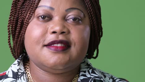 mujer africana hermosa con sobrepeso contra un fondo verde