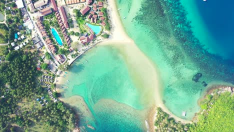 thailand, aerial - aquamarine sea water and sandy beach in front of the luxury resort with swimming pools