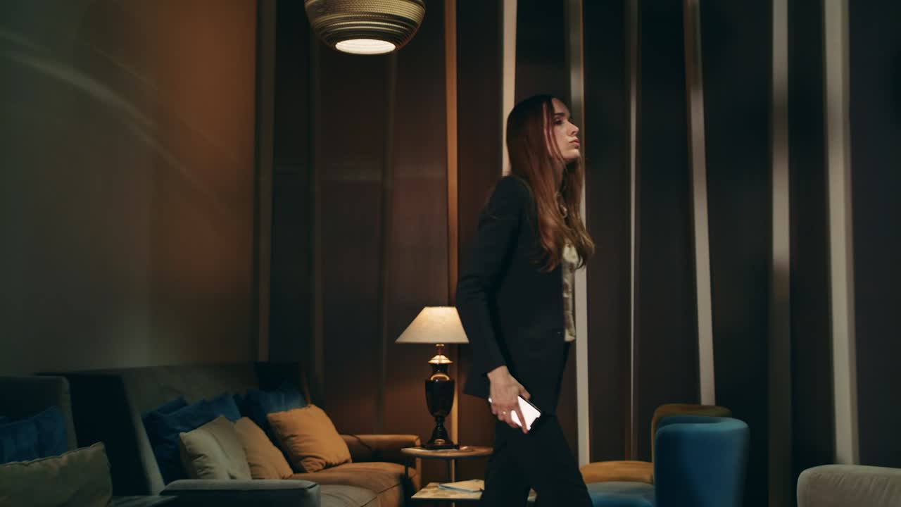 저녁에 사무실 라운지에서 휴대폰을 사용하는 긴장 한 전문가