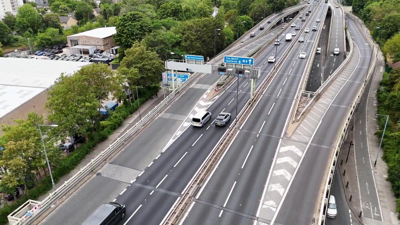 広い道路と駐車場の上の高架高速道路の湾曲した路面を走行する車両