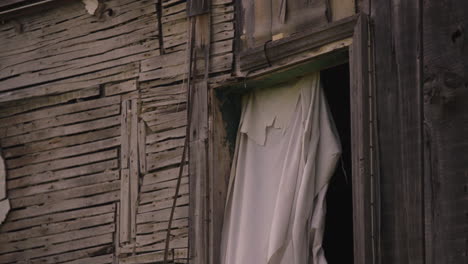 Post-apocalyptic-abandoned-home-strewn-together-with-wood-plank-boards-nails-and-sheet-curtain