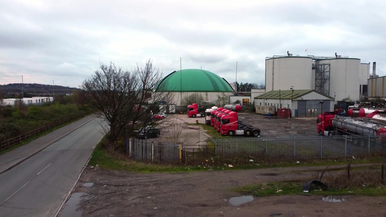 Aerial view rising over industrial green domed food waste biodegradable recycling silo facility