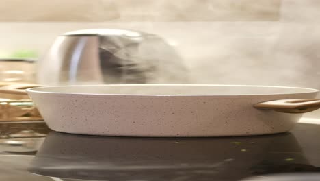 close up of a white pot with boiling water on a stovetop