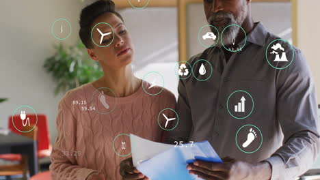 animación de procesamiento de datos e íconos de ecología sobre diversos colegas hablando en la oficina