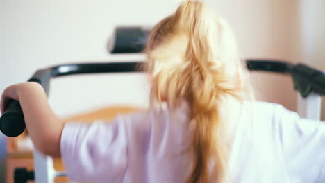 una niña rubia corre en una cinta de correr moderna en la parte trasera de la casa