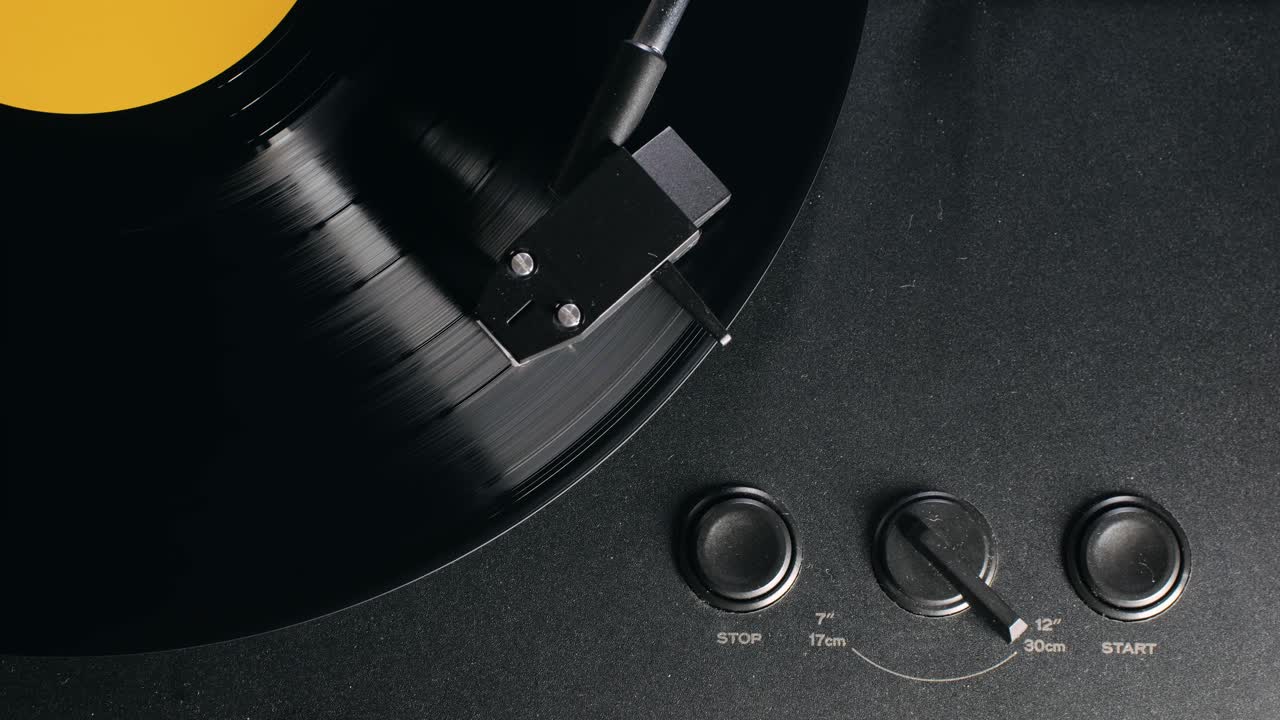 Retro Vinyl record player playing music, close-up macro shot of vintage LP disc old phonograph spinning. Retro music player.
