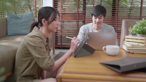 home finance,husband and wife discussing paper bill receipt from tablet laptop together on the floor at living room with focus and concentrate feeling with about family debt home interior background