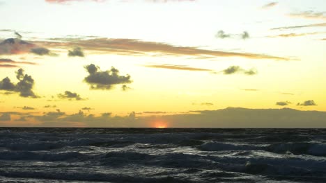 Amanecer-Sereno-Sobre-Las-Olas-Del-Océano-Pacífico-Con-Un-Cielo-Amarillo-Y-Naranja-Brillante