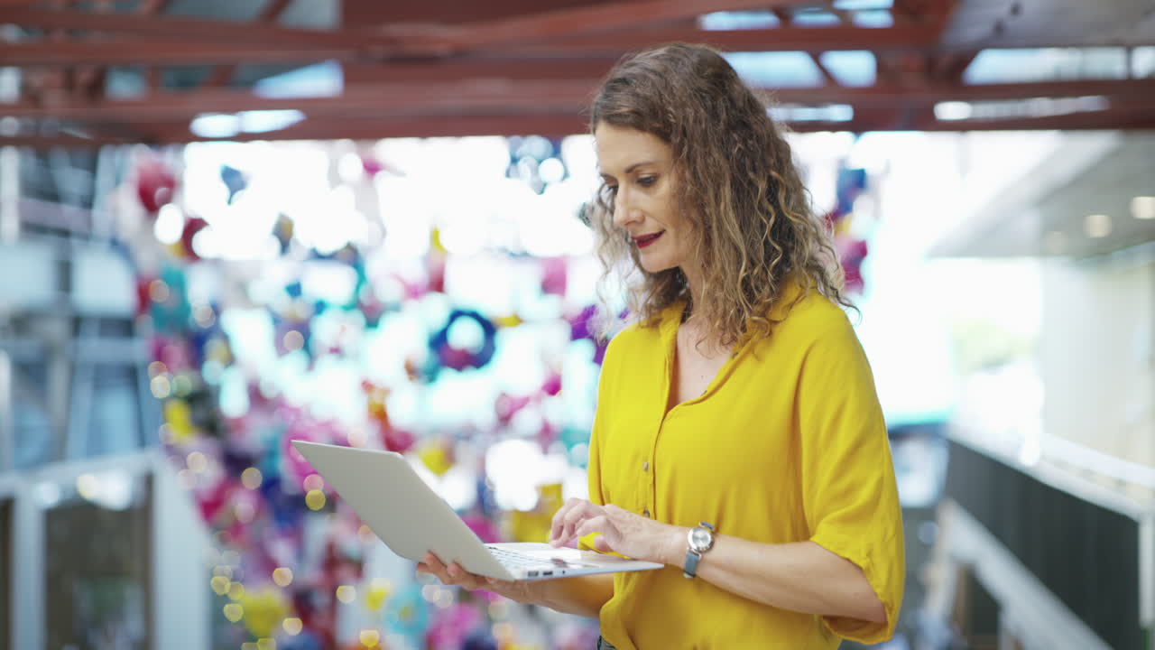 mujer trabajando en una computadora portátil en una oficina moderna