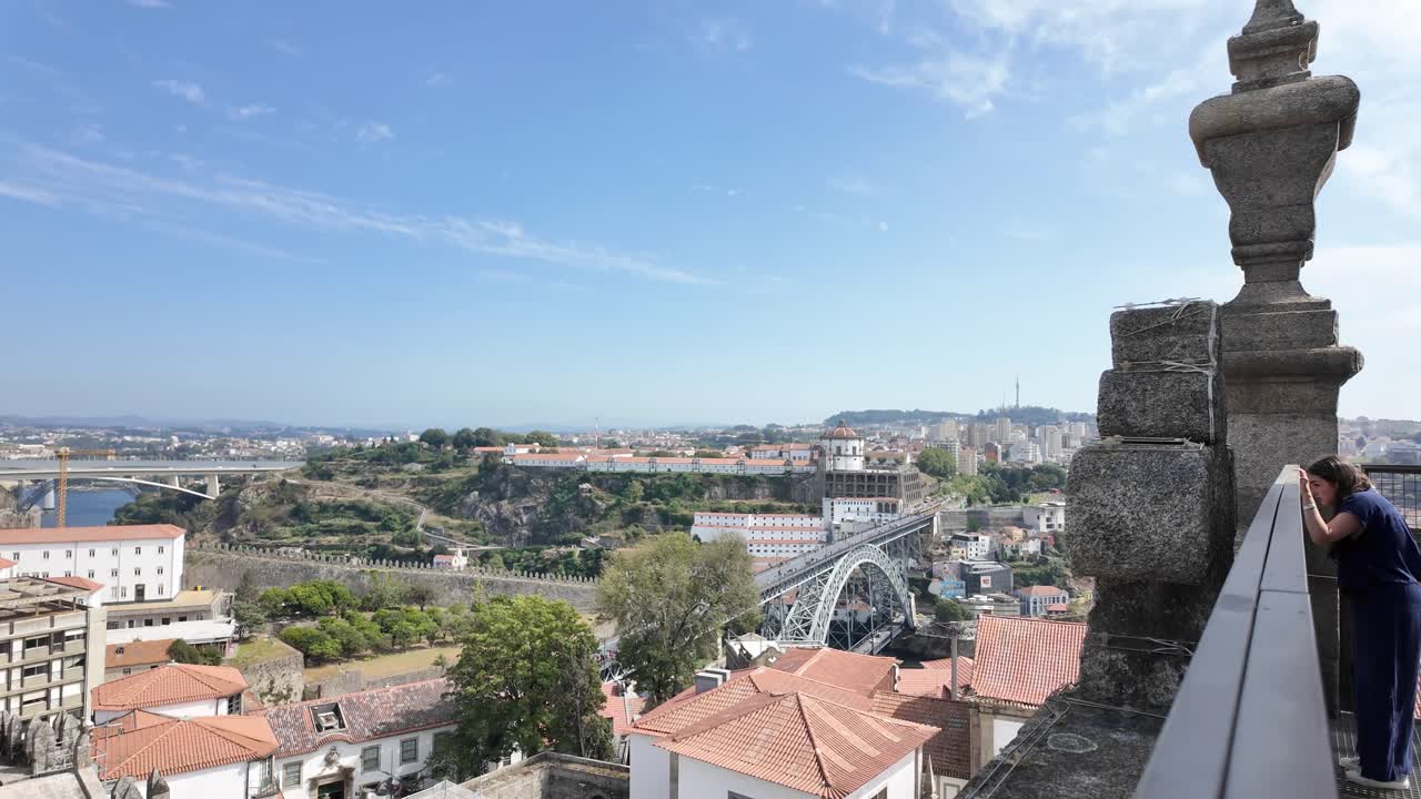 Porto with a scenic look at rooftops, a bridge, and the river on a sunny day, aerial view
