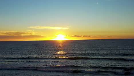 Aerial-of-the-sun-setting-over-the-horizon-on-an-ocean