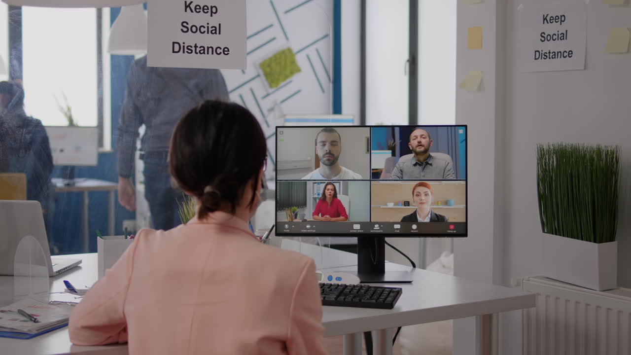 フェイスマスクをかぶったビジネスマンがコミュニケーションプロジェクトについてチームと話しています