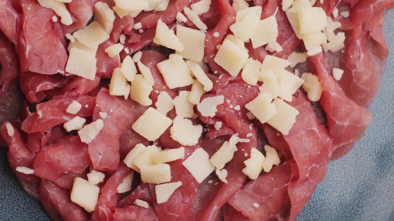 Primo piano di carpaccio di manzo italiano con scaglie di Parmigiano