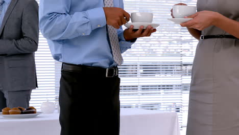 gente de negocios de pie y tomando café