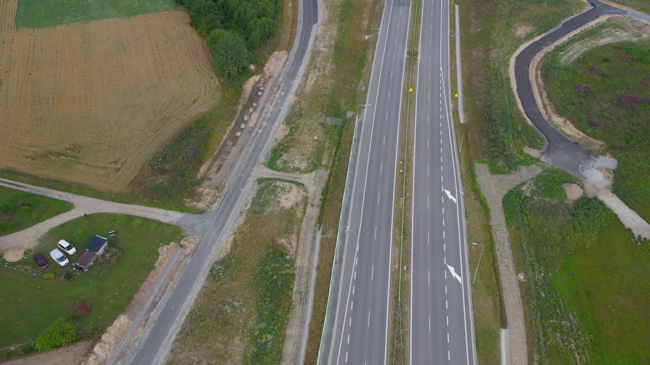 vista aérea volando por encima de los carriles vacíos de la autopista de transporte en un campo tranquilo