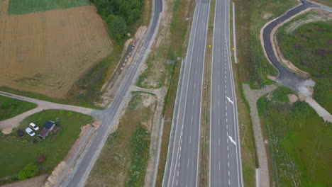 aerial view flying above empty transportation motorway lanes in quiet countryside