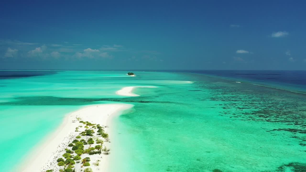 Flying over a sandbanks and uninhabited islands in Turquoise green water in Maldives