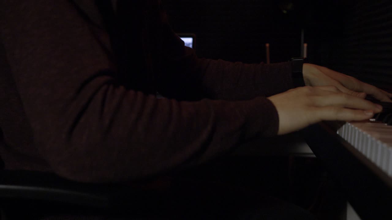 persona tocando el piano en un estudio de música