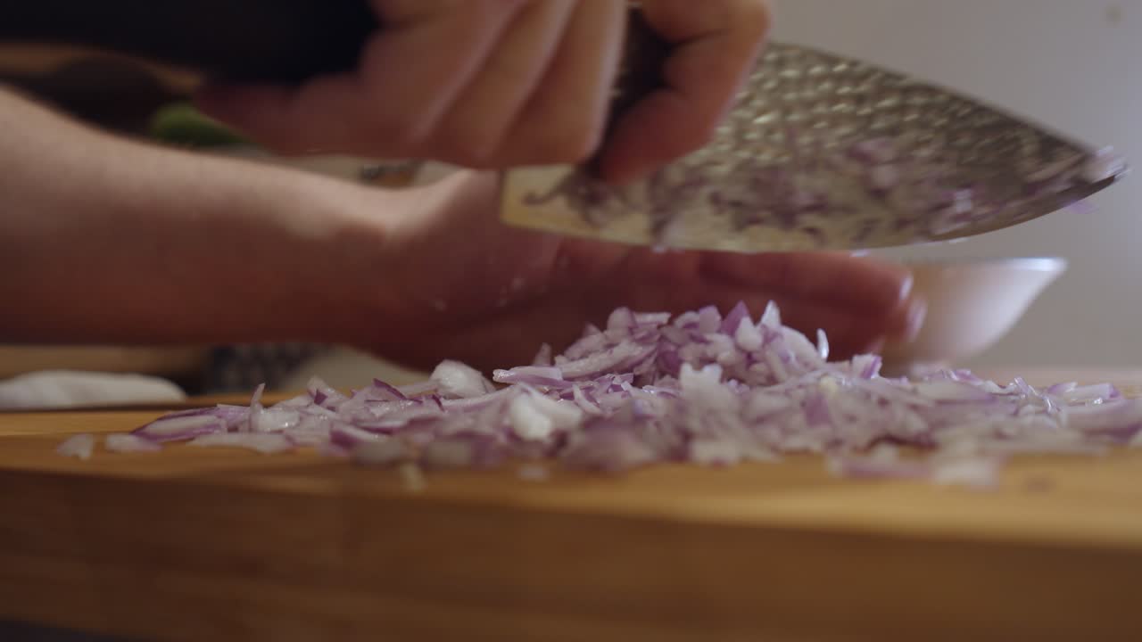 Chopping onion with sharp knife on a cut board
