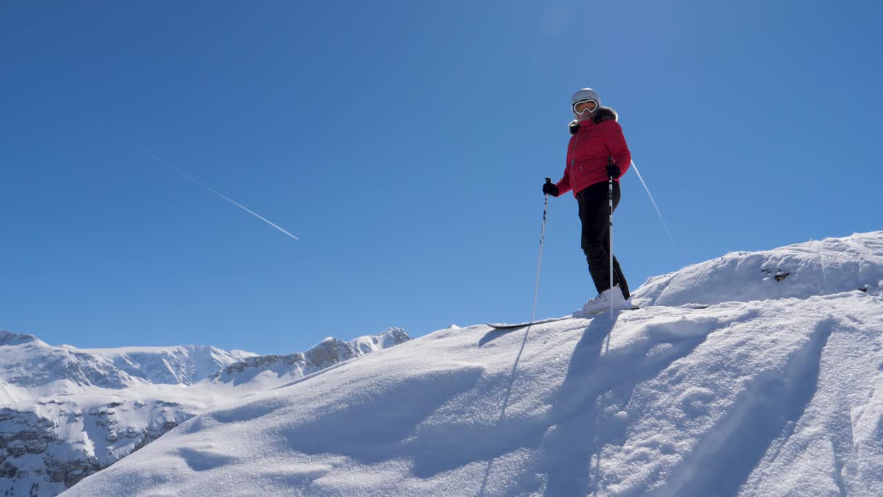 Ritratto di sciatore in piedi sul bordo che ammira il panorama delle montagne