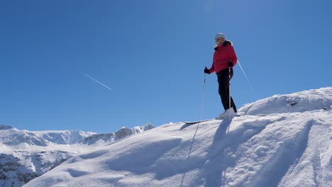 portrait skier standing on the edge and admiring the panorama of the mountains