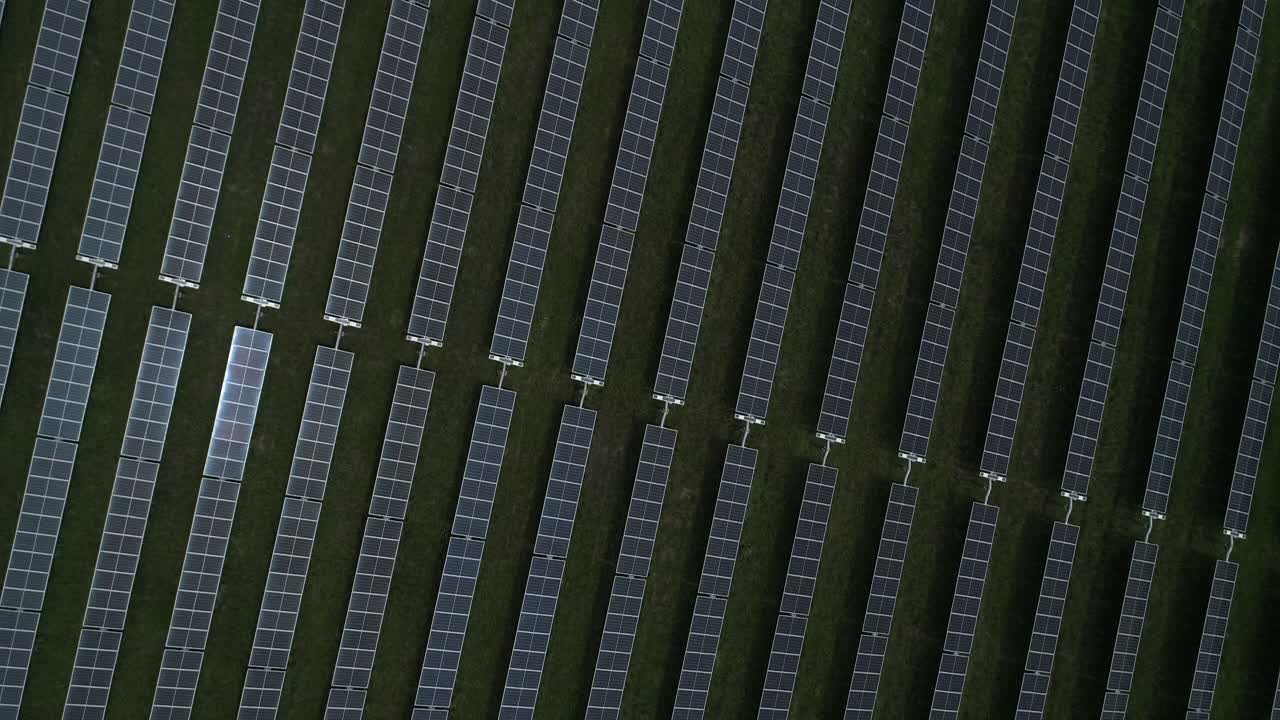 Aerial view of large solar farm with hundreds of rows of energy efficient panels, sustainable renewable energy
