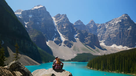 Couple-sitting-on-a-rock-near-riverside-4k