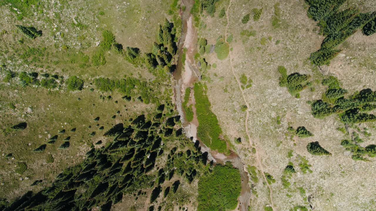 Top down wide aerial shot of a river winding through the mountains of the San Juan.