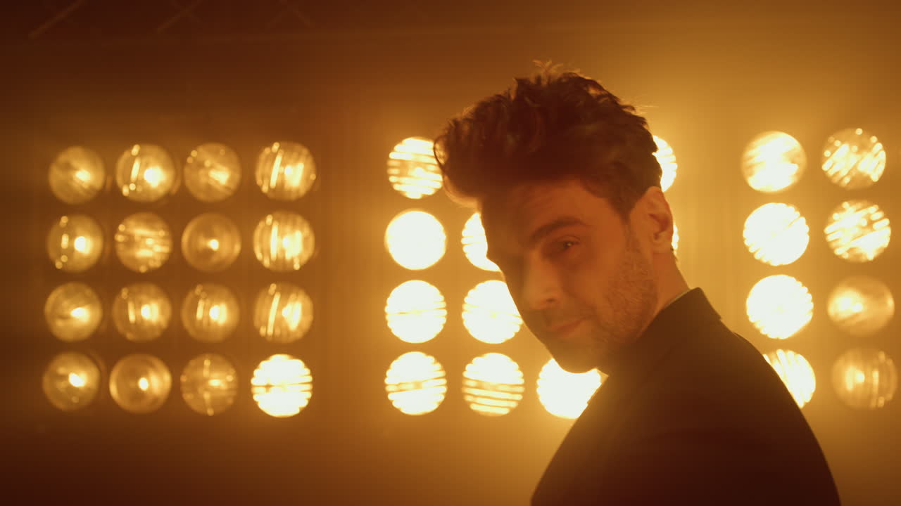 나이트클럽에서 손바닥을  ⁇ 는 모델 남자. 무대에서 움직이는 갈색 남자