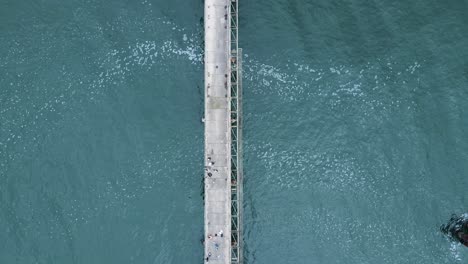 Unique-view-following-high-above-old-abandon-wharf-surrounded-by-the-ocean-waters