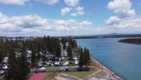 Aerial-view-of-a-skateboard-park,-a-caravan-park-near-a-river-and-a-coastal-town