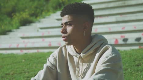 black sportsman sitting on steps in park