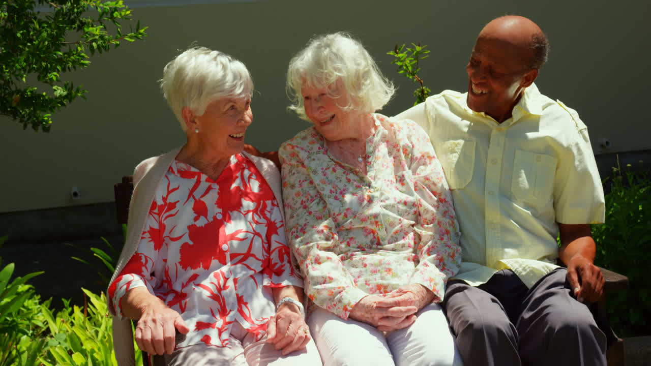 노인 가정 의 정원 에서 서로 상호 작용 하는 활동적 인 혼혈 노인 친구 들 의 그룹
