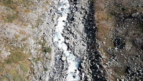 mountain-river-stream-topview,-Birdseye-aerial-drone-overview,-creek-melt-water-in-green-mountains-landscape