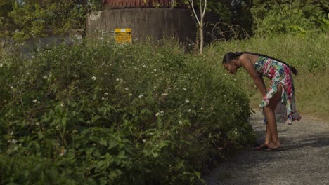 A-young-woman-in-a-long-flower-dress-walks-and-smell-the-roses-before-revealing-a-radar-tracking-station