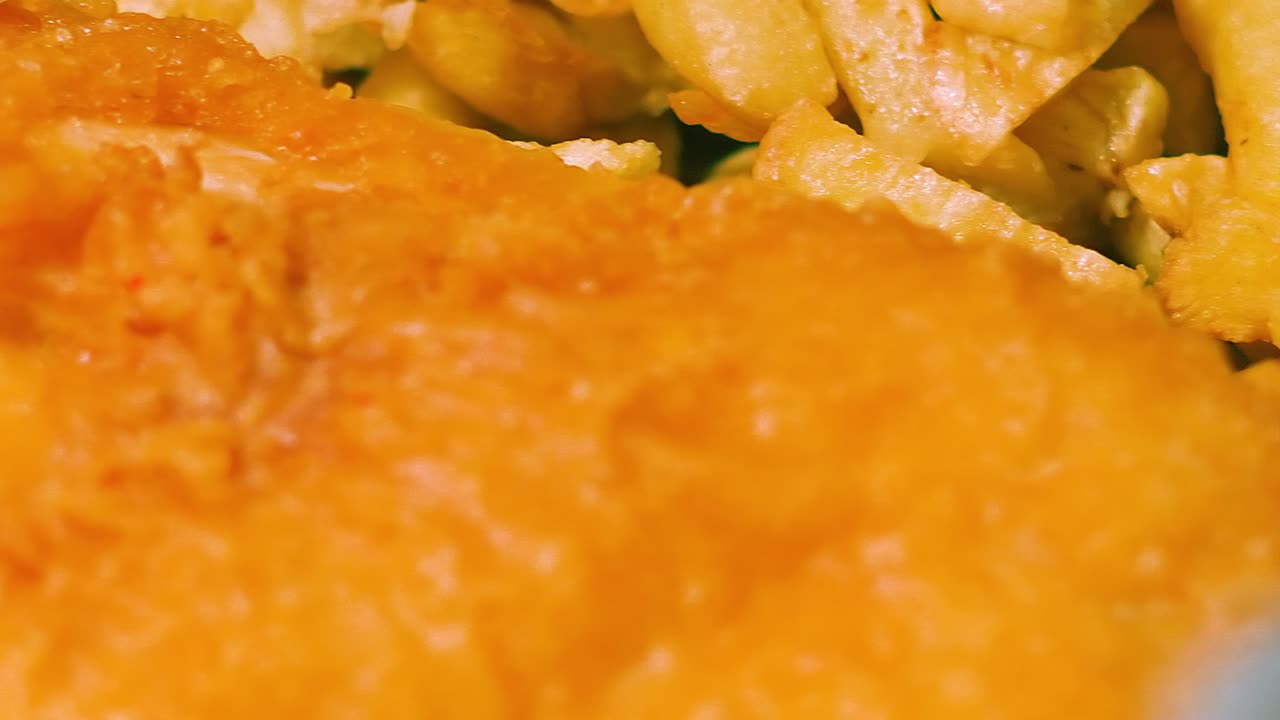Close Up of British Fish and Chips as Camera Moves from Chips to Battered Fish Ready to Eat. Deep Fried Fresh Cod Seafood Takeaway Served in Britain