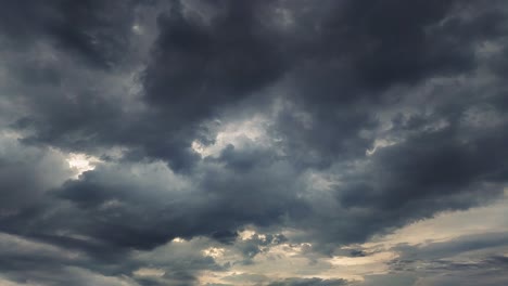 timelapse of dramatic dark storm clouds moving fast with sunlight peeking through. perfect for cinematic skies, weather transitions and mood-setting b-roll footage.