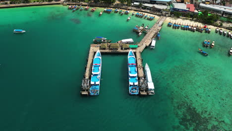 two big cruise ships are moored on the berth, while tiny fishing boats are moored near the shore