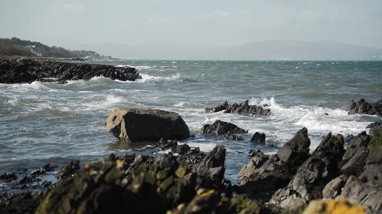 Onde che si infrangono su una riva rocciosa, al rallentatore.