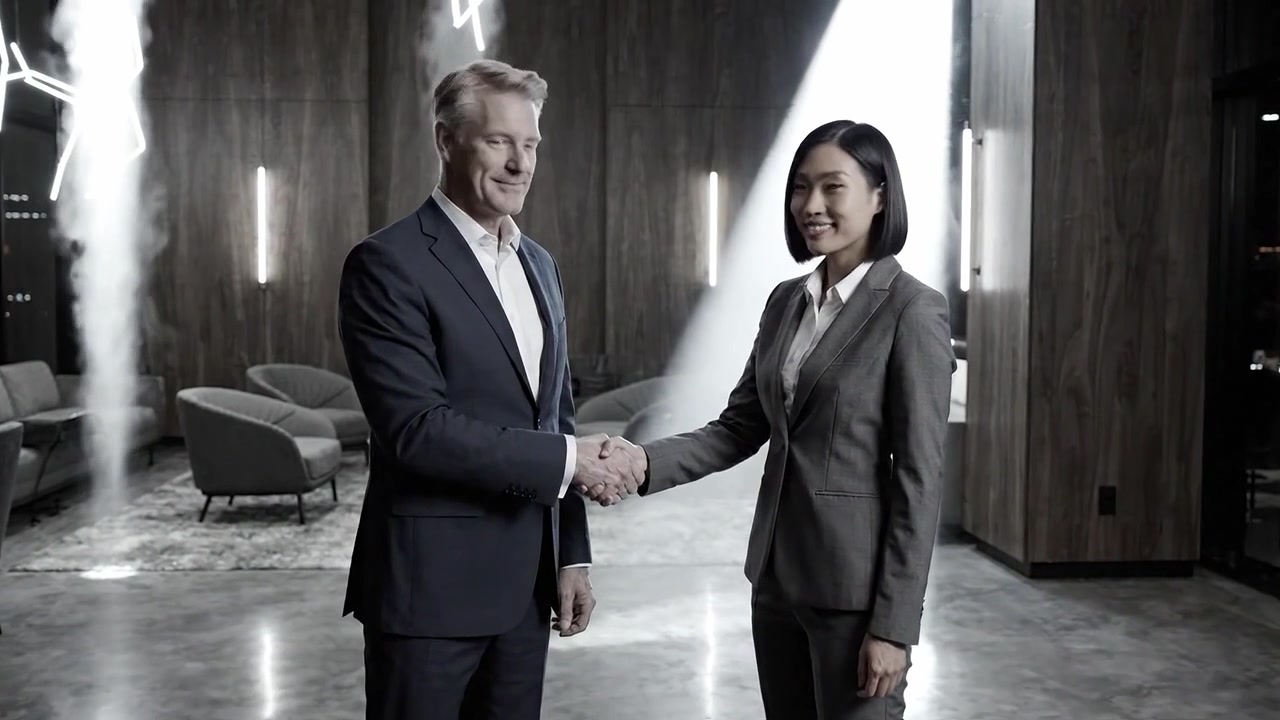 Una stretta di mano professionale tra due partner commerciali in un moderno ambiente d'ufficio con illuminazione dinamica e arredamento sofisticato che riflette successo e collaborazione.