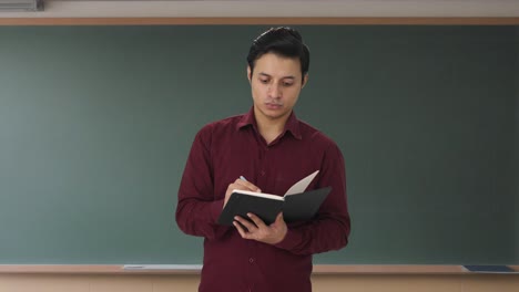 indian teacher taking attendance in class