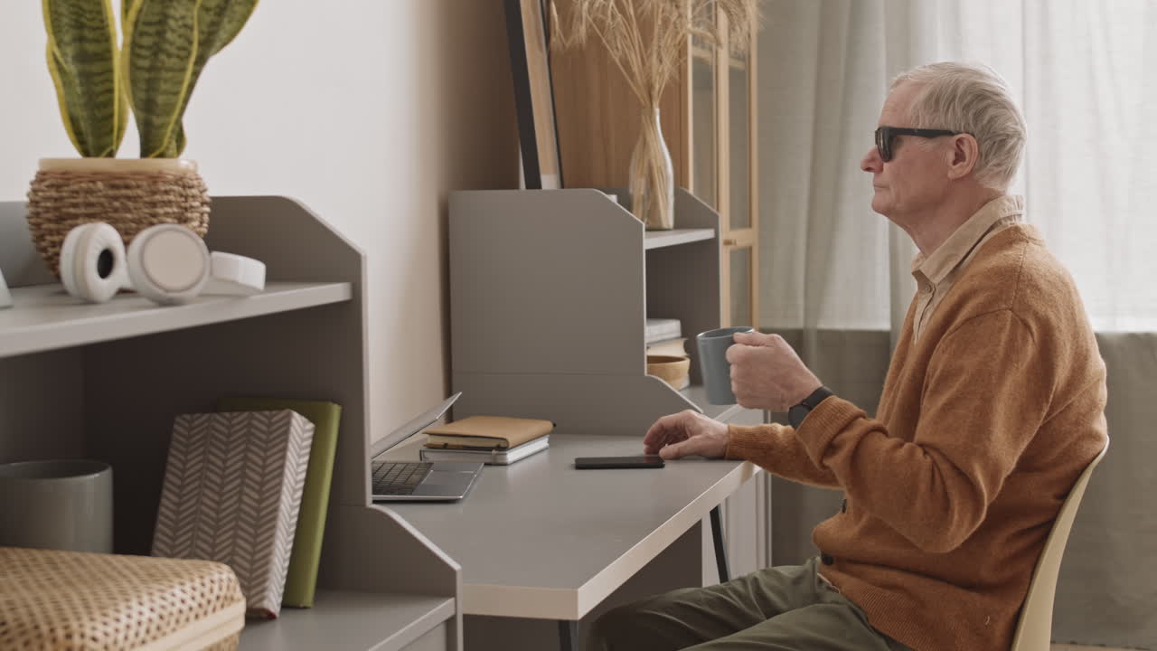 Blind Senior Man Drinking Tea at Home