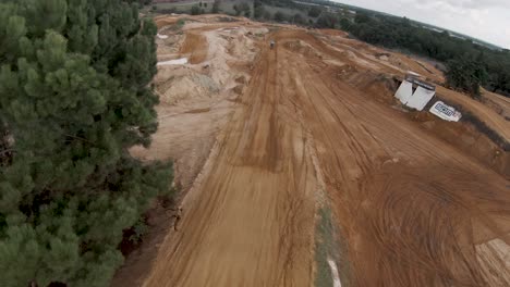 fpv aerial view over motocross riders relaxing and rider banking on turn