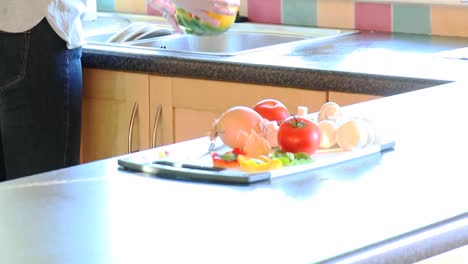 young woman rinsing vegetables to make a salad