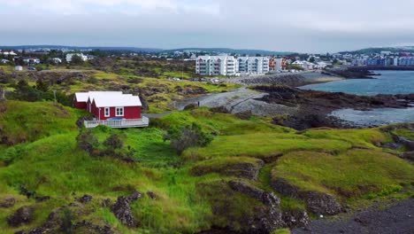 rugged terrain and high-rise buildings at the seafront in gardabaer, iceland