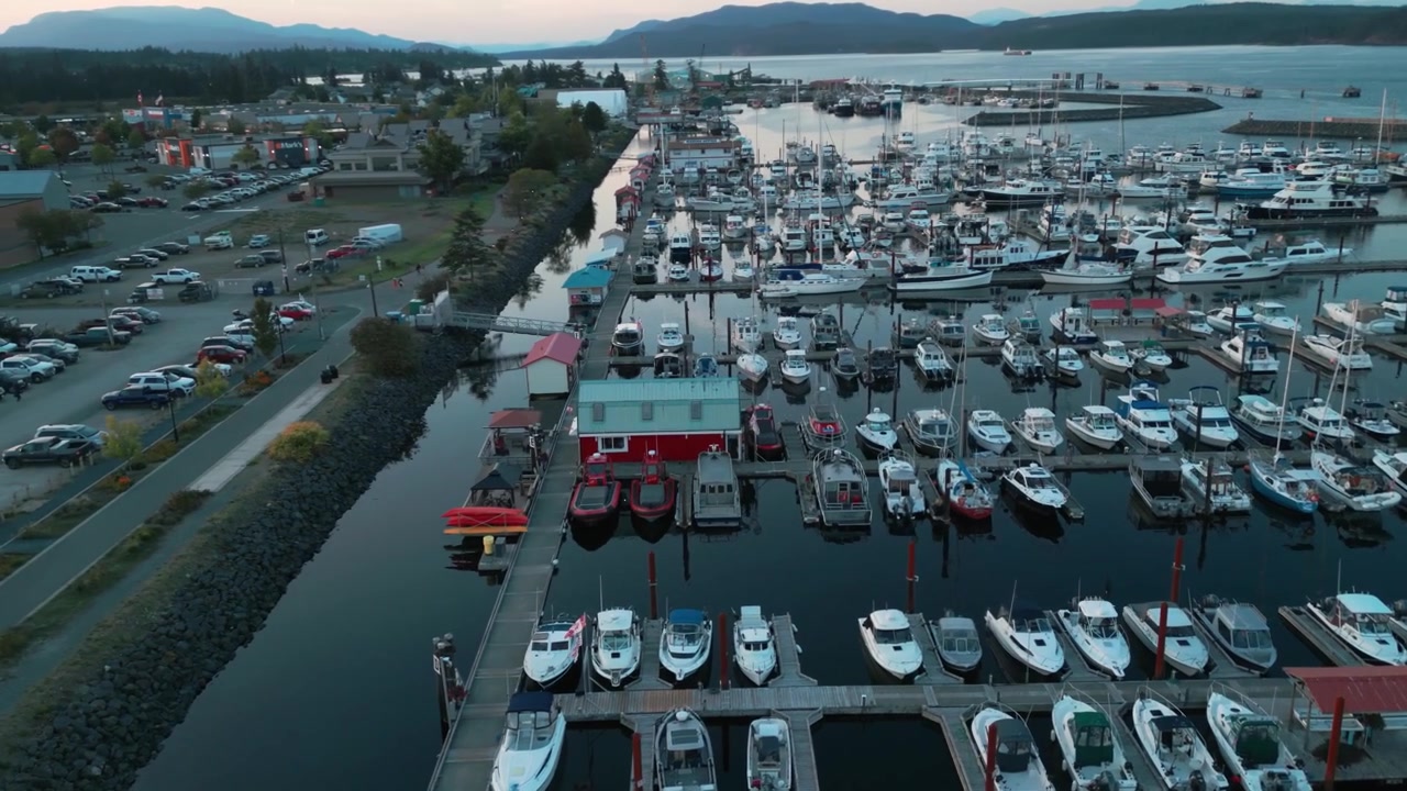 Luftfoto over Discovery Harbour Marina i Campbell River på en skyet dag ved solnedgang, med Discovery Passage og et kjøpesenter i bakgrunnen, Vancouver Island, Britisk Columbia, Canada