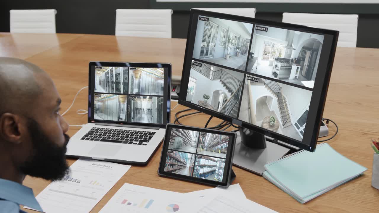 oficial de seguridad afroamericano viendo las vistas de las cámaras de cctv en pantallas de computadora, cámara lenta